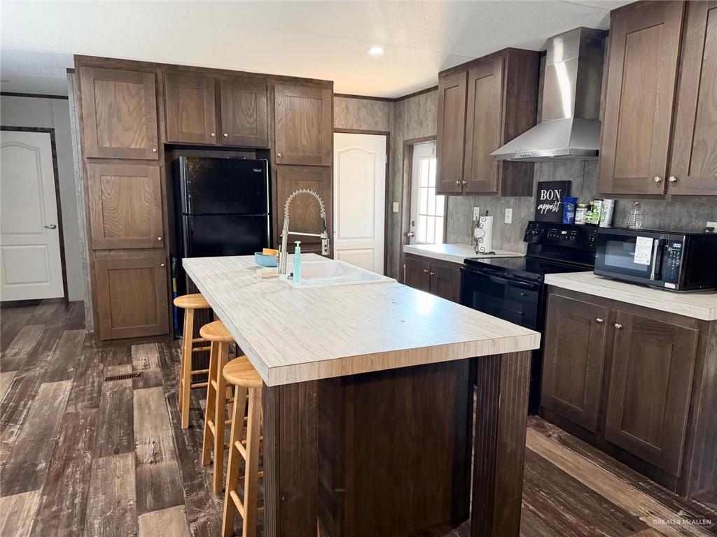 8511 Western Road Mission, TX 78574 - Photo 5 of 15 a kitchen with stainless steel appliances kitchen island granite countertop a refrigerator a sink dishwasher a stove with wooden cabinets and floor