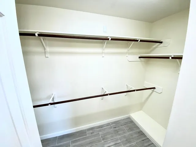 a view of walk in closet with empty racks