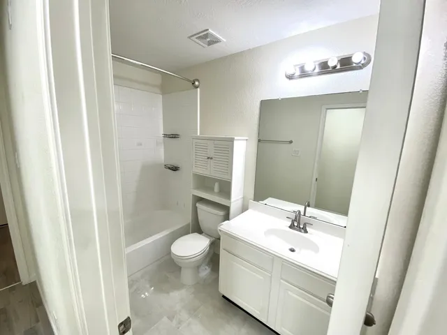 a bathroom with a double vanity sink mirror and toilet