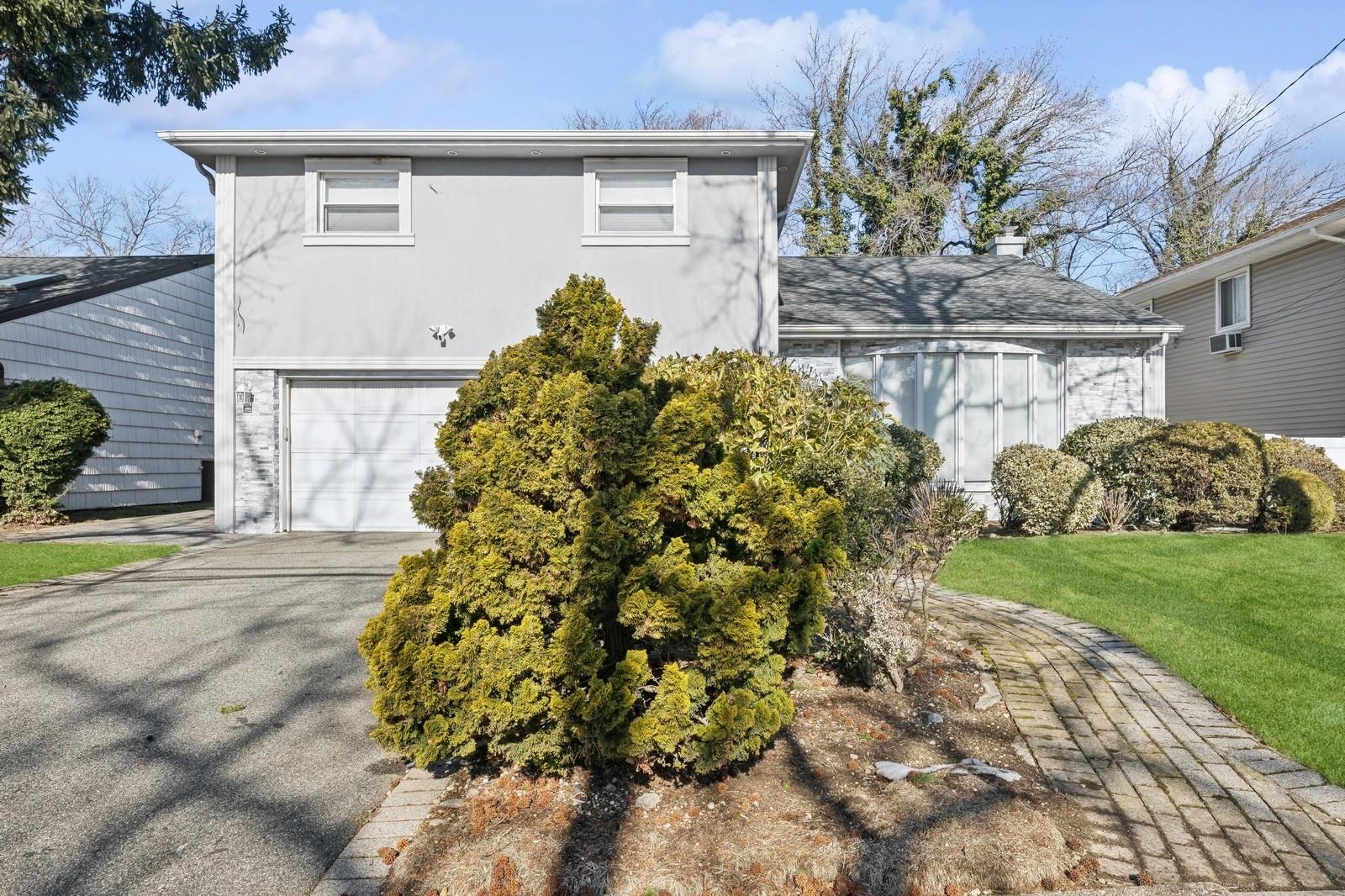 View of front of property featuring a front yard and a garage