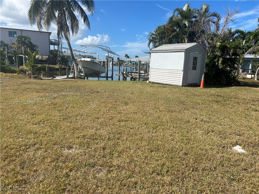 2635 York Road St. James City, FL 33956 - Photo 4 of 6 a view of a white house with a yard and potted plants