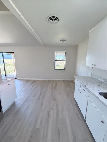 a view of a kitchen with wooden floor and a sink