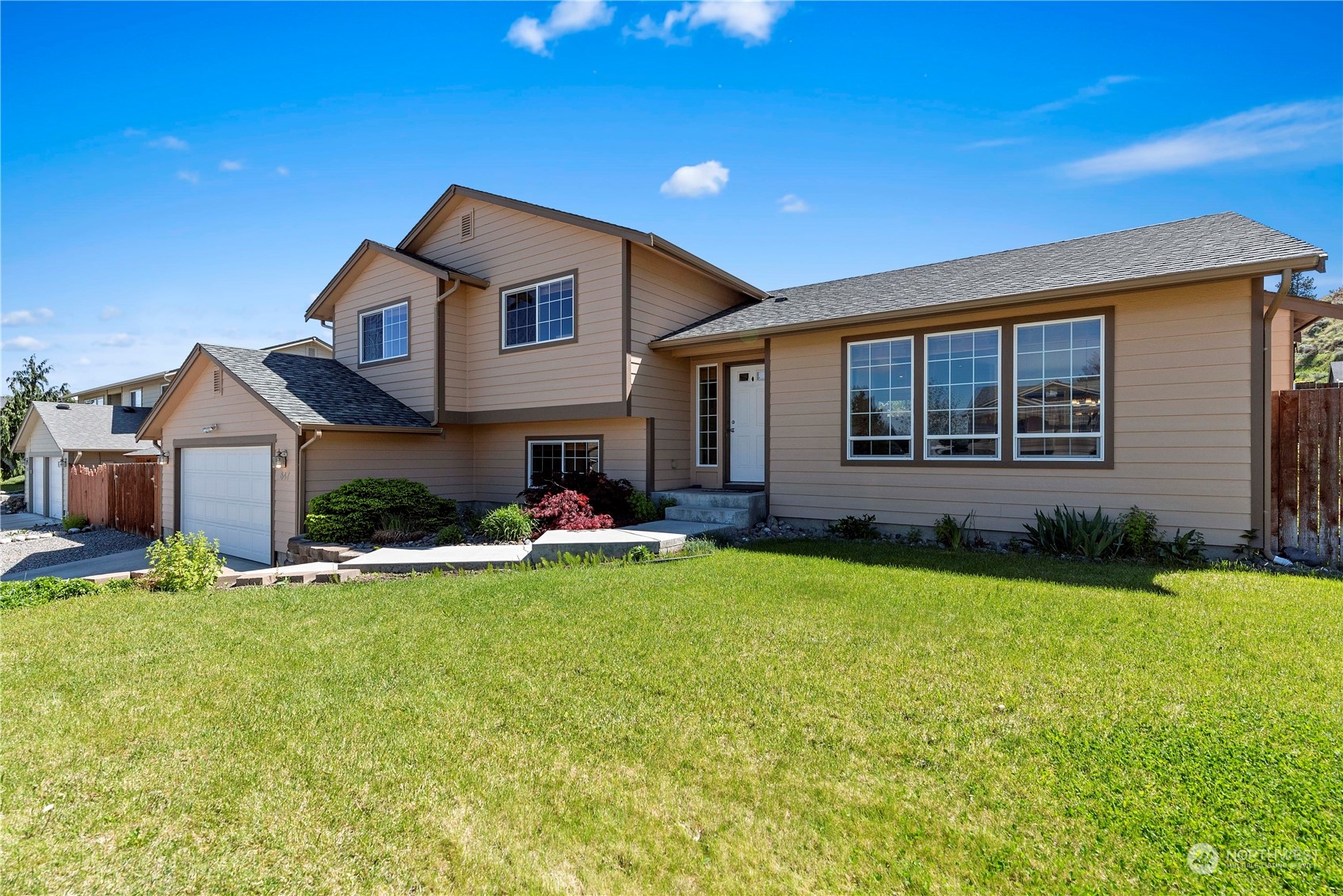 547 Saddle Rock Loop Wenatchee, WA 98801 - Photo 2 of 36 a front view of a house with a yard and garage