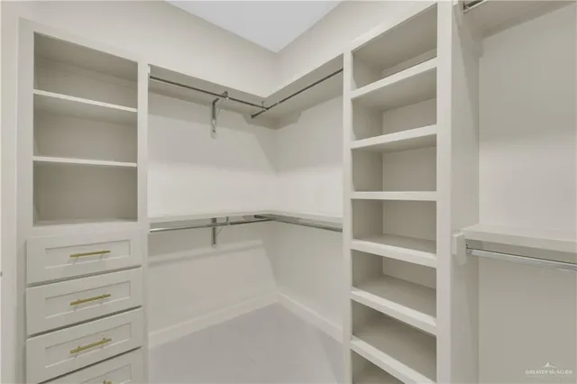 a view of walk in closet with empty racks