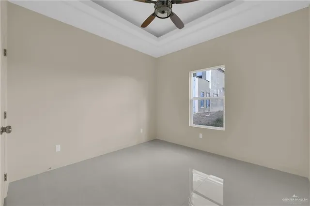 an empty room with a ceiling fan and window
