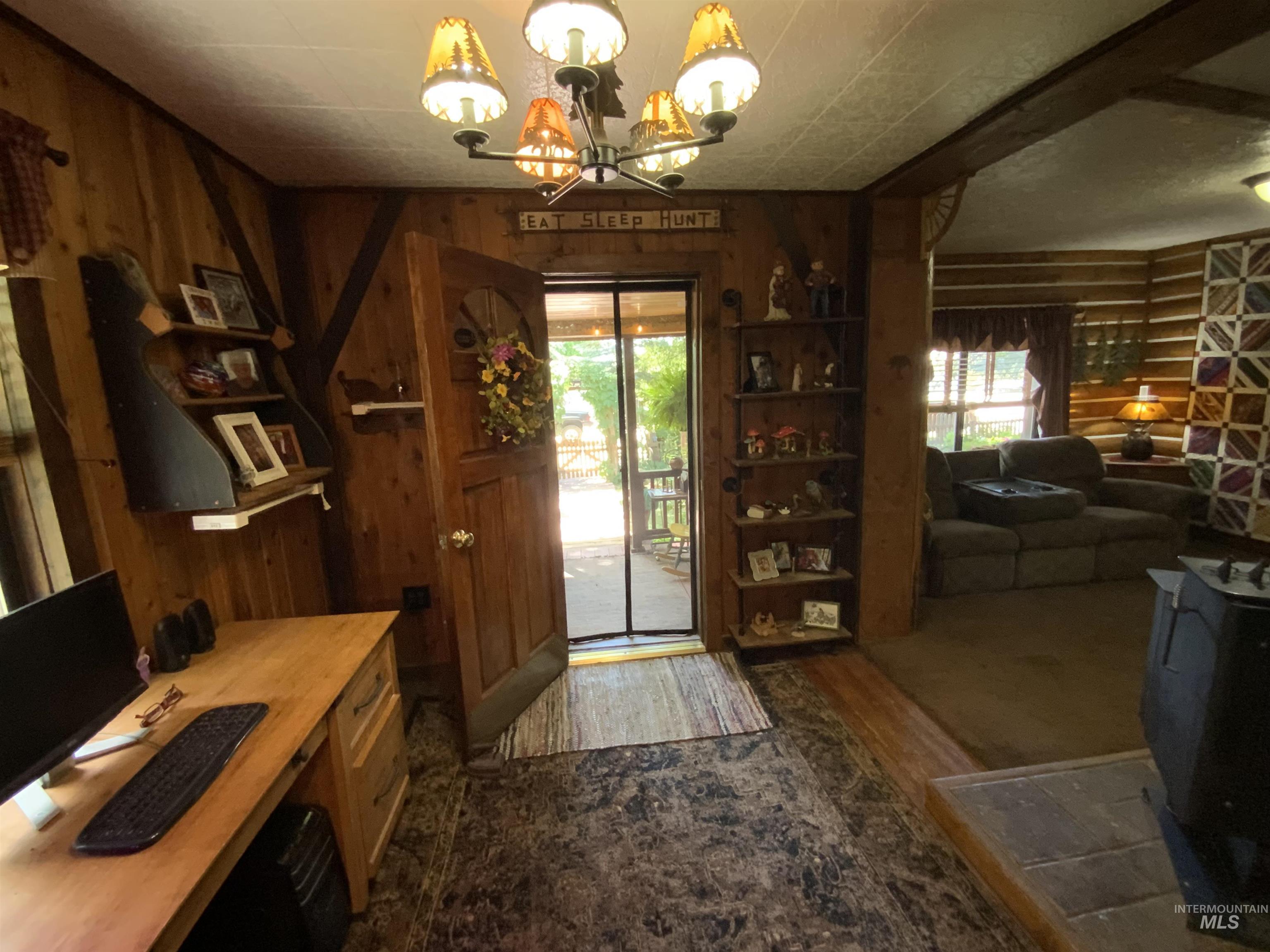 205 Alturas Avenue East Fairfield, ID 83327 - Photo 19 of 39 Foyer entrance featuring hanging lights, dark wood-style floors, and wooden walls