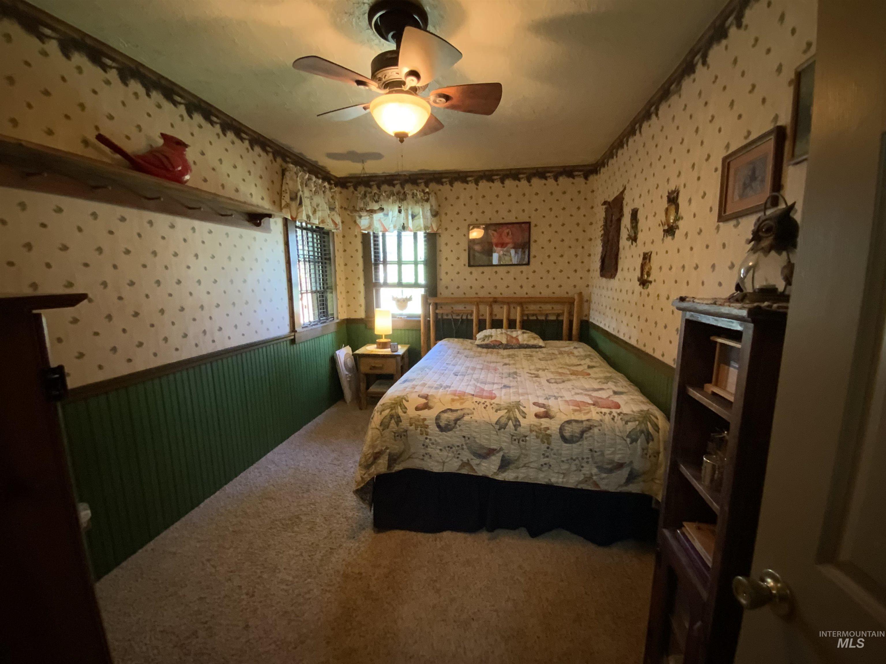 205 Alturas Avenue East Fairfield, ID 83327 - Photo 25 of 39 Carpeted bedroom with wallpapered walls, a wainscoted wall, and ceiling fan