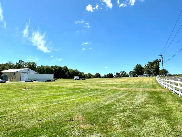 a backyard of a house with lots of green space and outdoor seating
