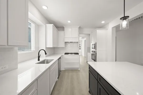 a kitchen with kitchen island sink stove and refrigerator
