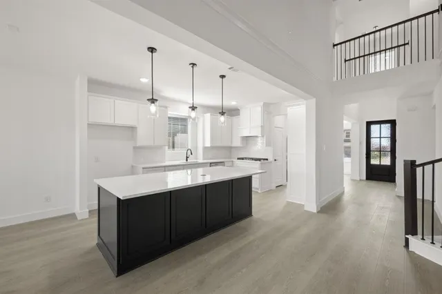 a kitchen with a sink refrigerator and cabinets