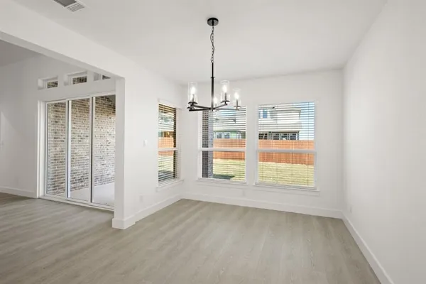 an empty room with windows & cabinet