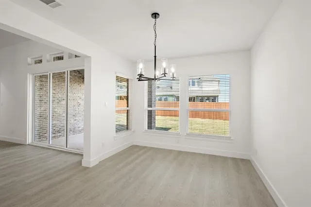 an empty room with windows & cabinet