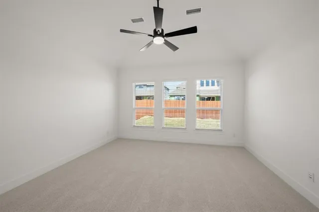 an empty room with a window and a fan