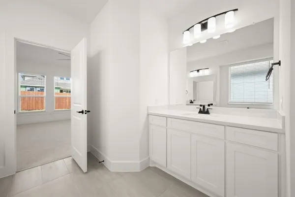 a bathroom with a double vanity sink mirror and next to a white cabinet