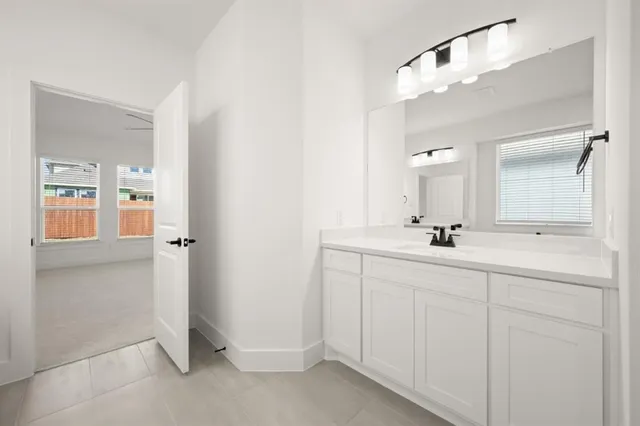 a bathroom with a double vanity sink mirror and next to a white cabinet