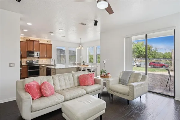 a open kitchen with stainless steel appliances granite countertop a sink dishwasher a dining table and chairs with wooden floor