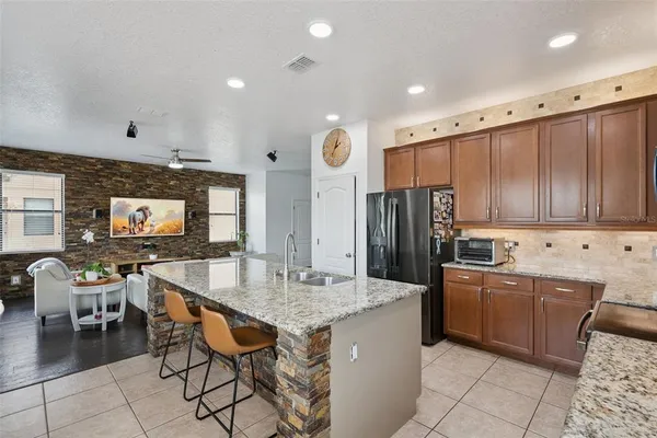 a kitchen with kitchen island granite countertop a stove cabinets and refrigerator