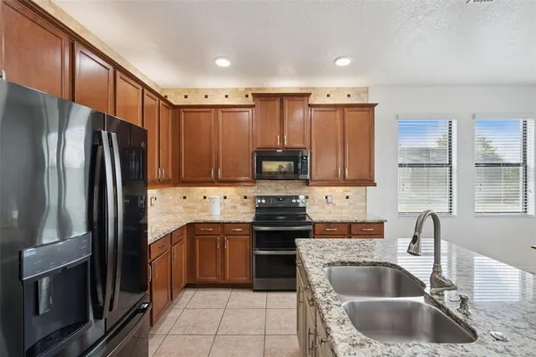 a bedroom with a bed a chandelier and a window