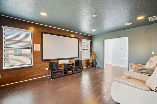 a view of a livingroom with furniture a flat screen tv and wooden floor