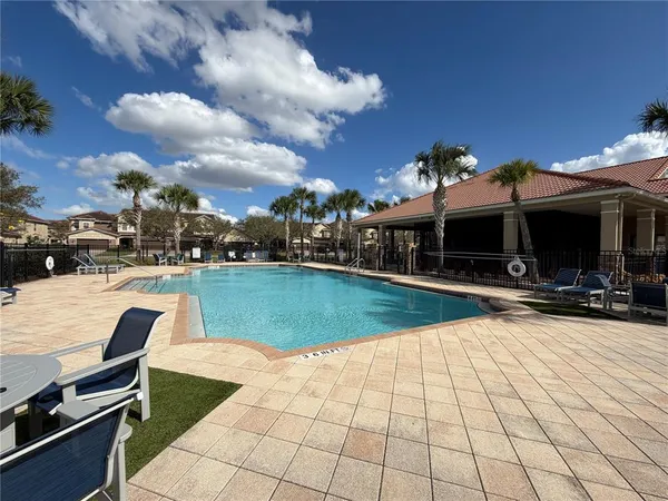 a view of a patio with a table chairs and a barbeque