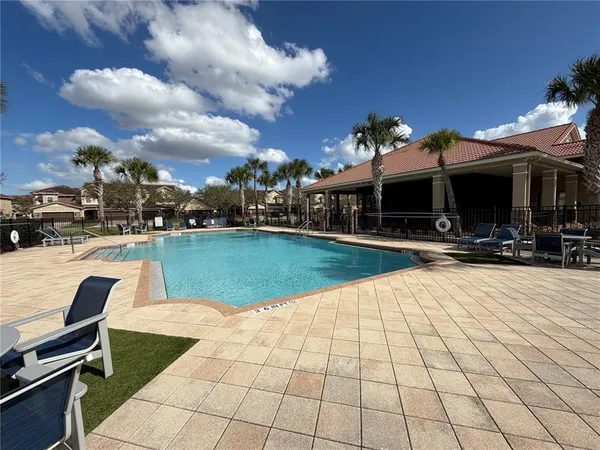 a view of a house with swimming pool and sitting area