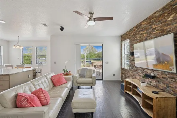 a kitchen with stainless steel appliances granite countertop a stove top oven a sink a dining table and chairs with wooden floor