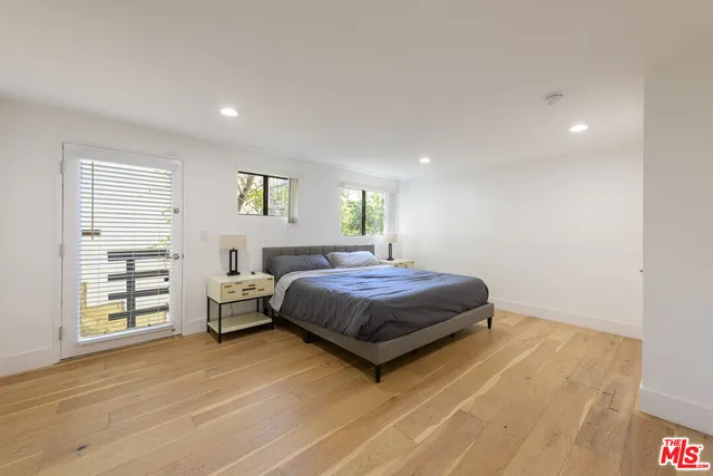 a bedroom with a bed and a large window