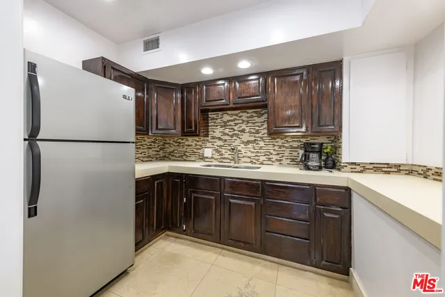 a kitchen with stainless steel appliances granite countertop a refrigerator a sink and a stove