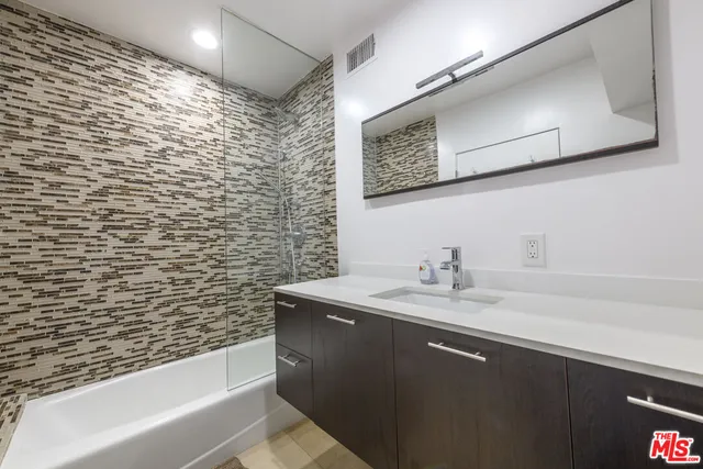 a bathroom with a sink a toilet and mirror