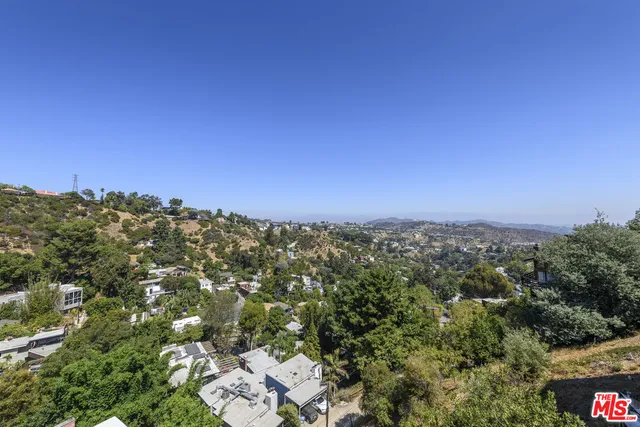 an aerial view of house with yard and mountain view in back