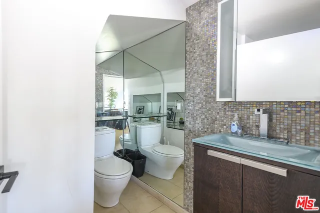 a bathroom with a granite countertop sink a toilet and a mirror