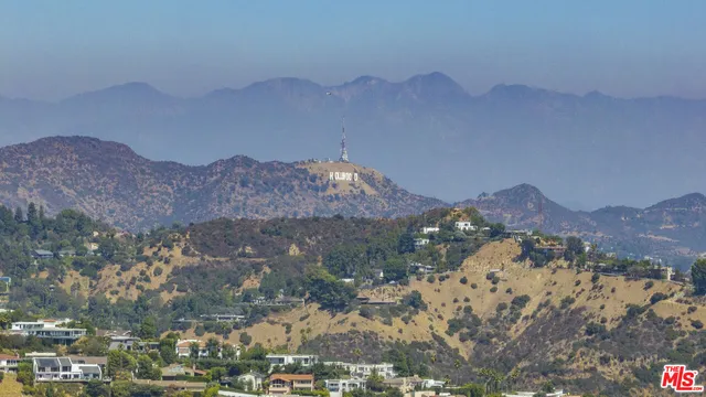 an aerial view of house with yard and mountain view in back