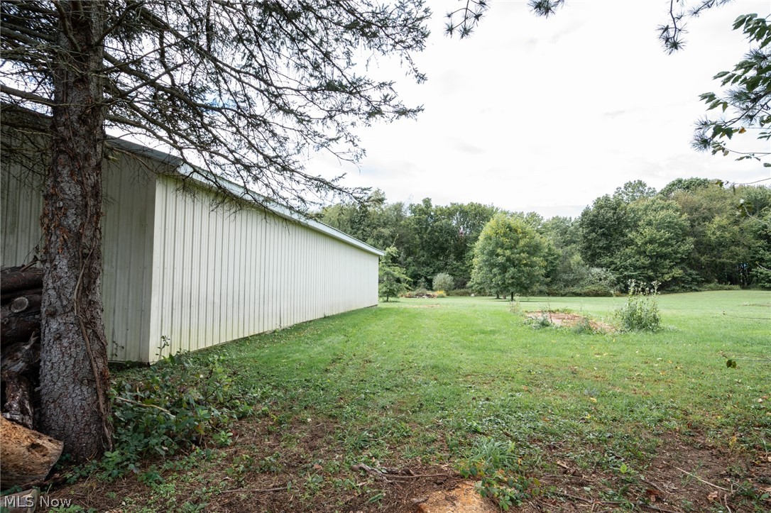 7005 Fee Road Rome, OH 44085 - Photo 32 of 36 Spacious green lawn bordering a long, light-colored vertical siding structure