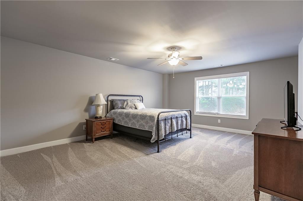 2875 Fox Wood Lane Gainesville, GA 30504 - Photo 18 of 24 a spacious bedroom with a bed and a flat screen tv