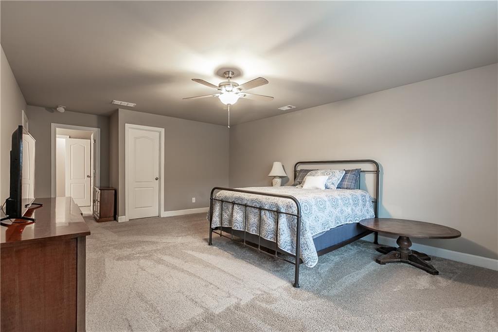 2875 Fox Wood Lane Gainesville, GA 30504 - Photo 19 of 24 a spacious bedroom with a bed and a chandelier