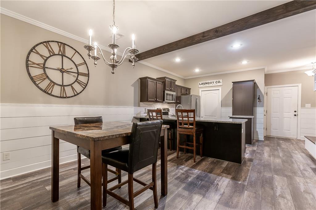 2875 Fox Wood Lane Gainesville, GA 30504 - Photo 9 of 24 a kitchen with stainless steel appliances granite countertop a stove top oven a sink dishwasher a dining table and chairs with wooden floor