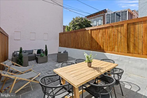 a view of a patio with table and chairs and potted plants