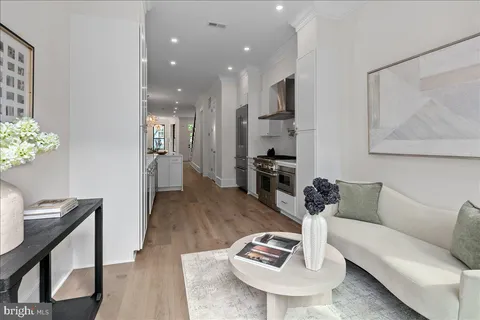 a living room with furniture kitchen view and a table