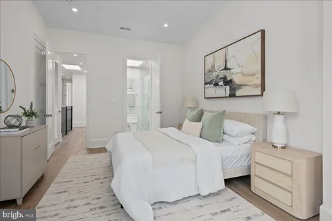 a bedroom with a white bed and a chandelier