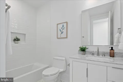 a bathroom with a granite countertop sink a toilet and shower