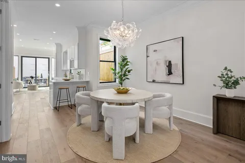 a living room with dining table and a large mirror