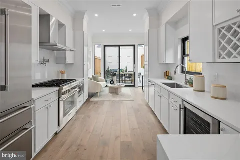 a large kitchen with stainless steel appliances lots of counter space and a sink
