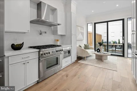 a kitchen with stainless steel appliances a stove and white cabinets