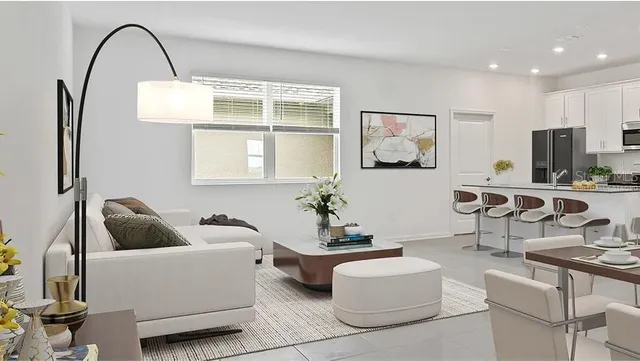 a living room with furniture a window and a potted plant