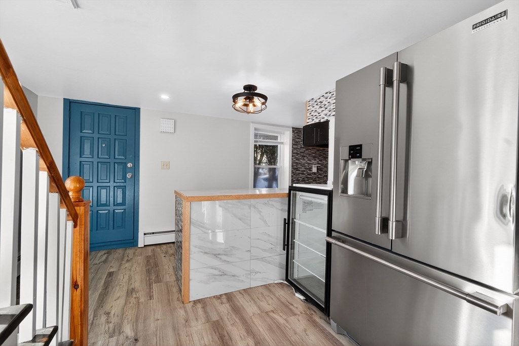 240 Montaup Street Fall River, MA 02724 - Photo 2 of 16 a kitchen with stainless steel appliances a refrigerator and a wooden floor