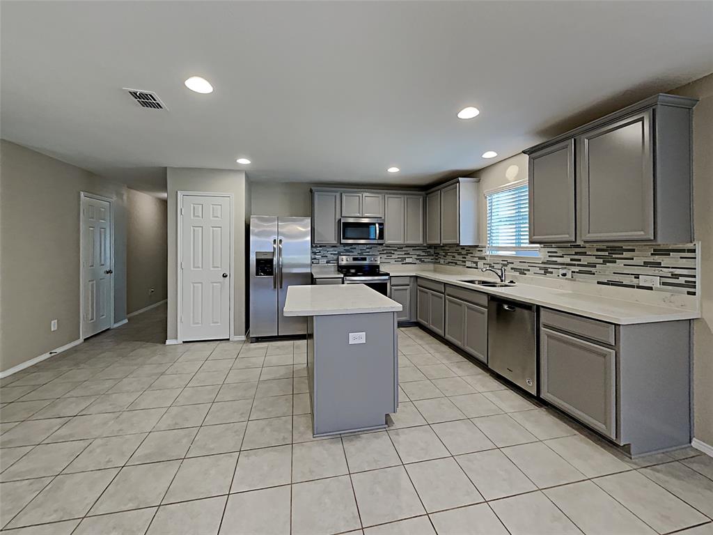 2220 Heaton Street Forney, TX 75126 - Photo 3 of 11 a kitchen with stainless steel appliances granite countertop a stove a sink a microwave a counter top and cabinets