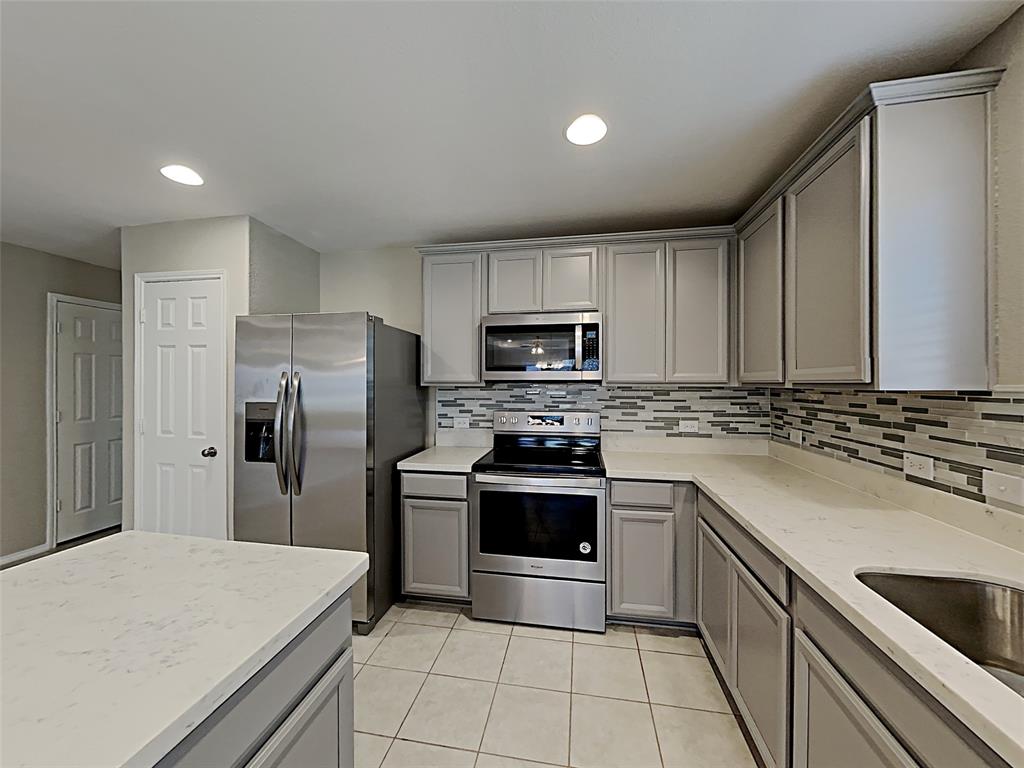 2220 Heaton Street Forney, TX 75126 - Photo 4 of 11 a kitchen with a stove sink and refrigerator