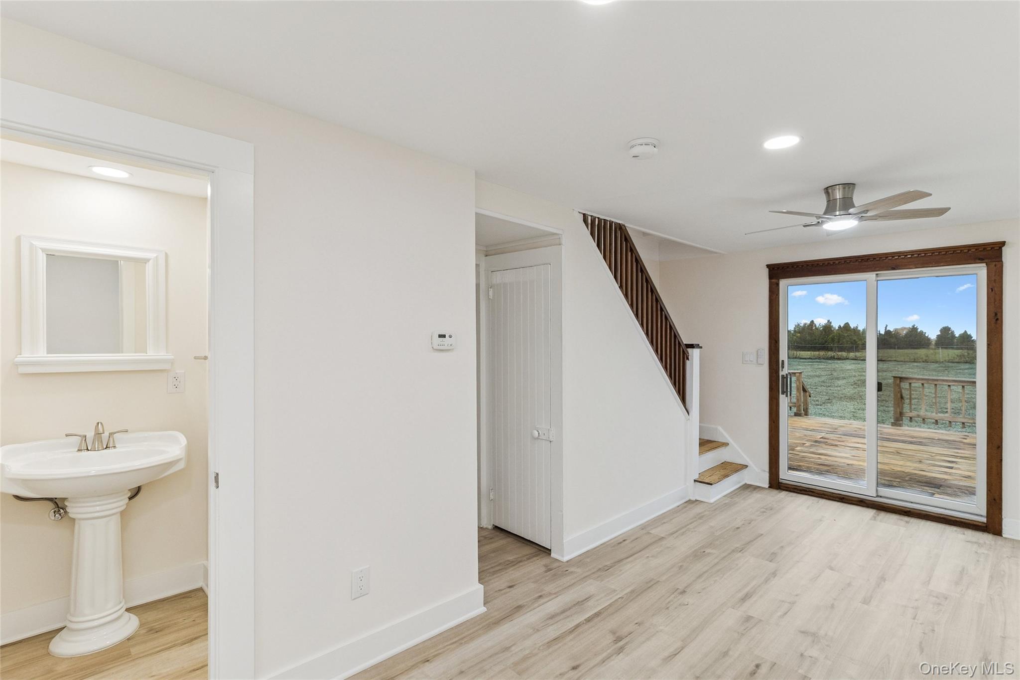 17425 County Road 48 Cutchogue, NY 11935 - Photo 14 of 30 Unfurnished living room featuring light wood finished floors, stairway, a ceiling fan, recessed lighting, and a water view