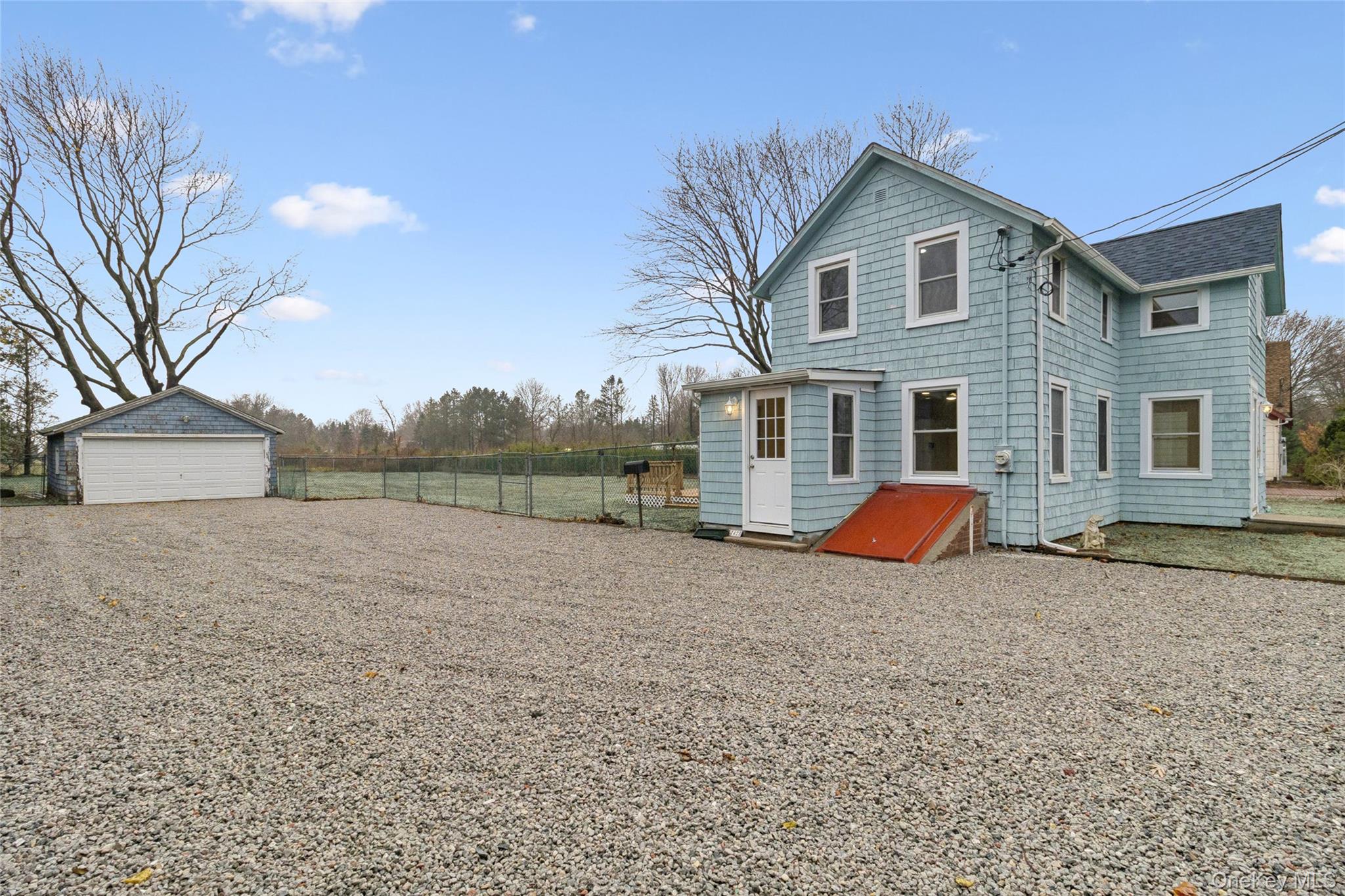 17425 County Road 48 Cutchogue, NY 11935 - Photo 5 of 30 Rear view of house featuring roof with shingles, an outdoor structure, and a detached garage