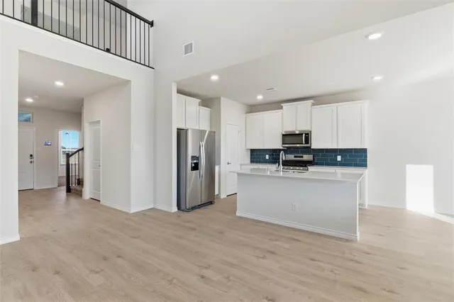 a kitchen with stainless steel appliances granite countertop a refrigerator and a sink